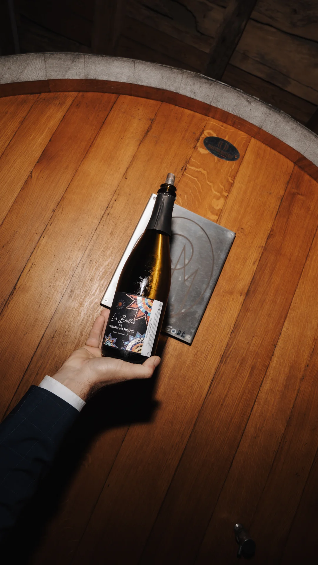 Bouteille des vins du domaine présentée sur un fût